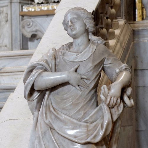La Carità, statua marmorea all'invito dello scalone del presbiterio, sec. XVIII