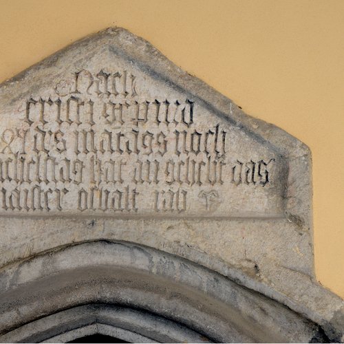 Lapide trapezoidale posta sopra il portone d’ingresso della chiesa