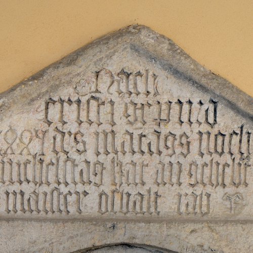 Lapide trapezoidale posta sopra il portone d’ingresso della chiesa