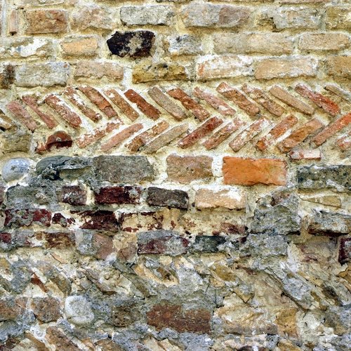 Paramento murario caratterizzato da filari interposti di pietrame, pezzi di mattoni romani sesquipedali ed embrici della stessa epoca